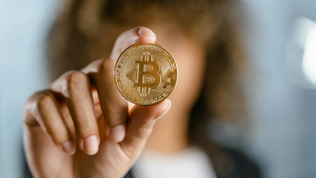 Close-up of a person holding a Bitcoin, symbolizing cryptocurrency and digital finance.