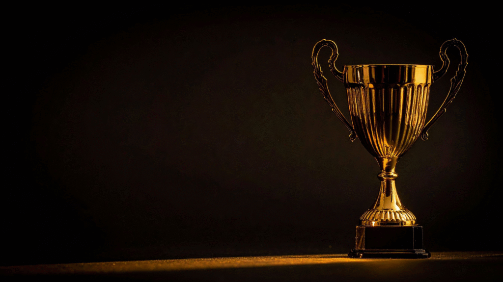 Golden trophy cup on dark background symbolizing achievement, recognition, and success